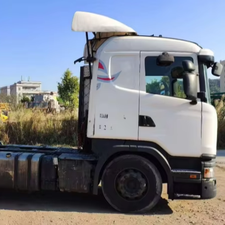 Outdoor side real shot of white used Scania G410 4x2 tractor head.