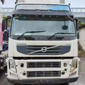 Special prices second hand for VOLVO FM440 6x2 tractor truck adequate stock available, 440HP heavy duty tractor with white cab and front grille, front close-up view