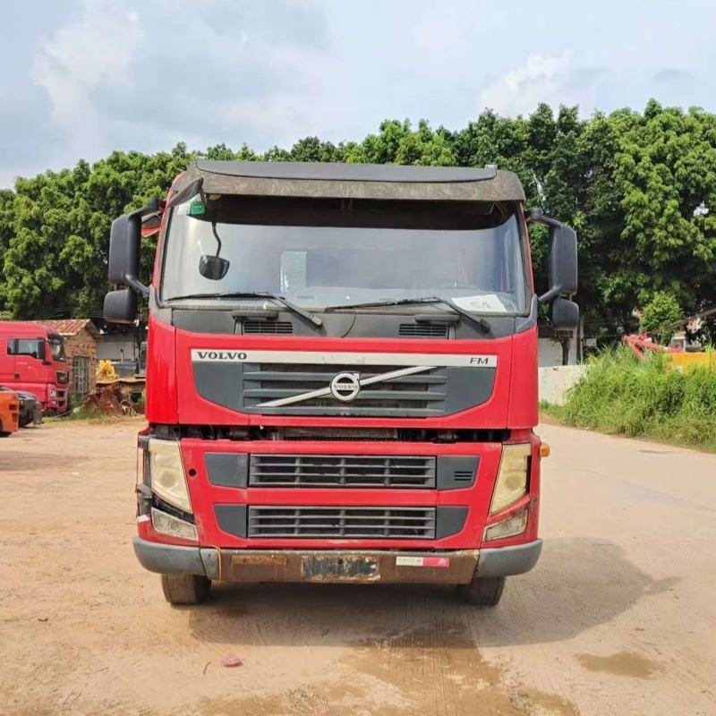 Lowest price used tractor truck for VOLVO FM440 6x2 2012 red manual transmission, 440HP heavy duty tractor with red cab and front grille, front face view outdoor scene