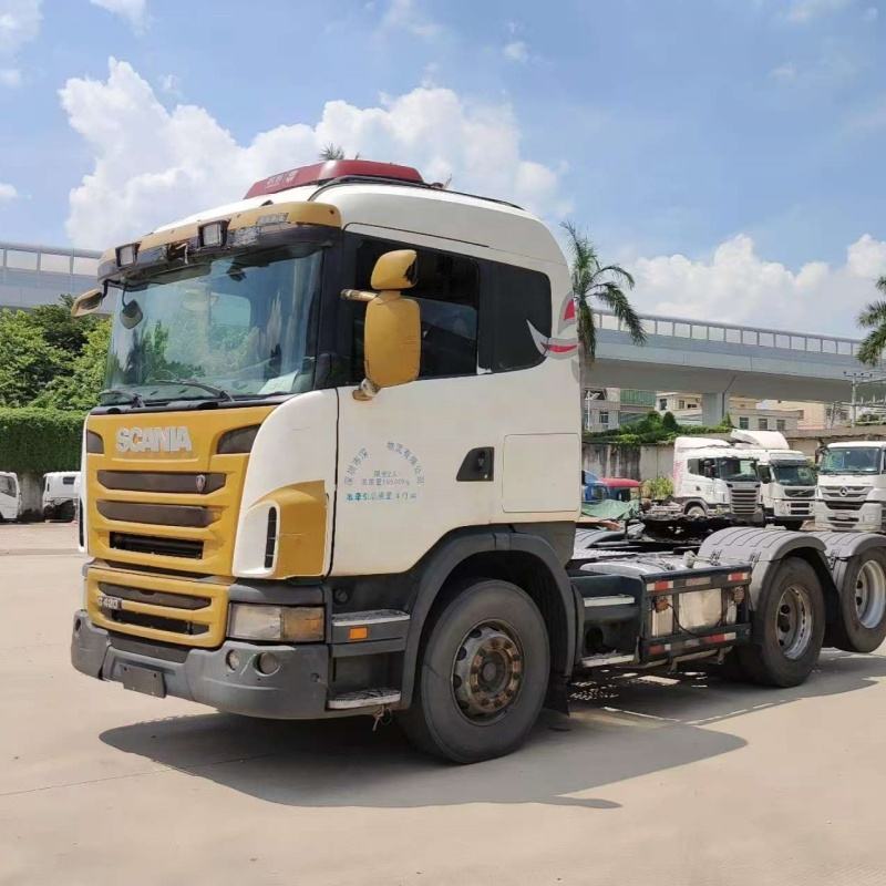 High quality used SCANIA G420 6x2 manual tractor truck, left front 45 degree view outdoor industrial storage yard scene