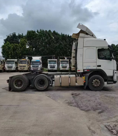 Special prices second hand for VOLVO FM440 6x2 tractor truck adequate stock available, 440HP heavy duty white tractor hauling trailer, left side view outdoor yard