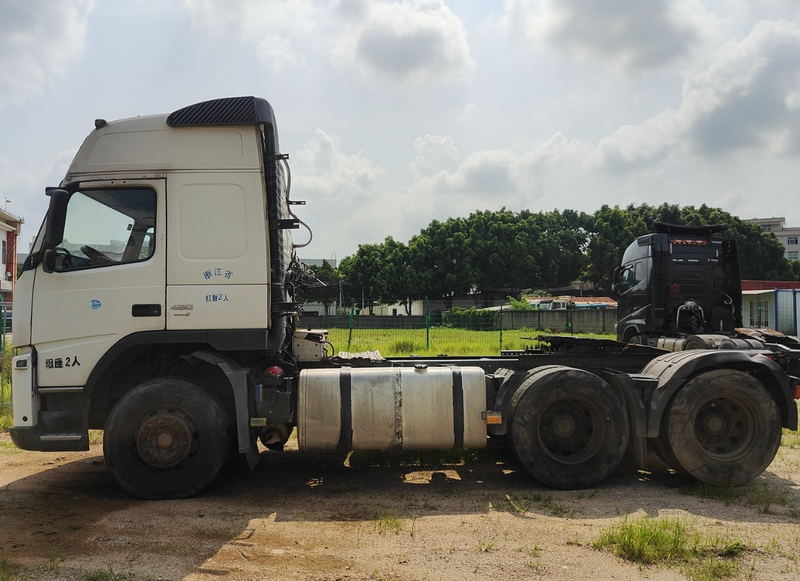 Second hand tractor truck for VOLVO FM480 6x2 high performance tractor trailer for sale, 480HP heavy duty white tractor, full left side view outdoor yard scene