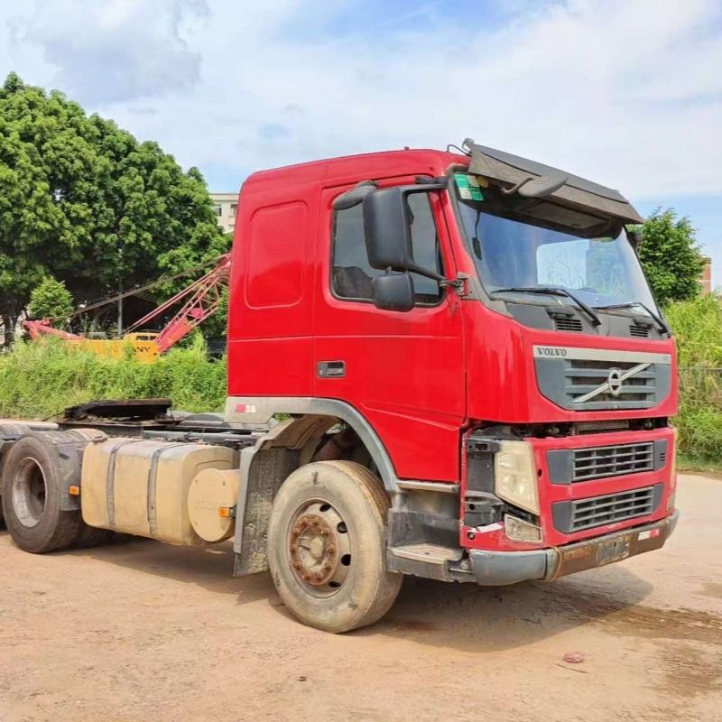 Lowest price used tractor truck for VOLVO FM440 6x2 2012 red manual transmission, 440HP heavy duty red tractor, left front side view outdoor yard