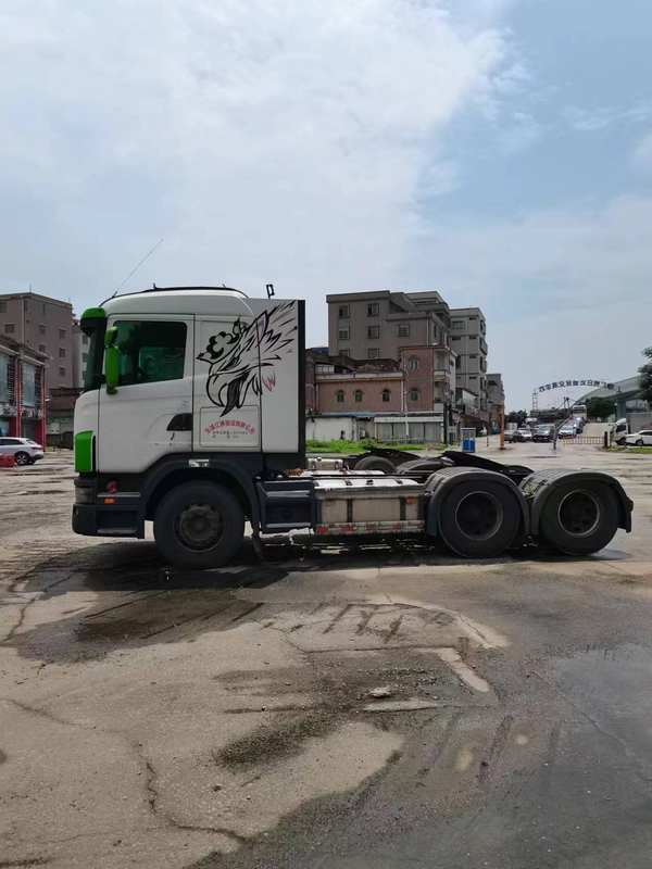 Low price multi-purpose used SCANIA G420 6x2 heavy tractor truck, right front 45 degree view in industrial storage yard