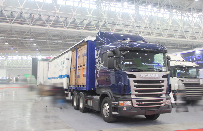 Used trailer truck good condition SCANIA 6X2 R440 tractor head for sale, 440HP heavy duty blue tractor hauling cargo trailer, left side view indoor warehouse scene