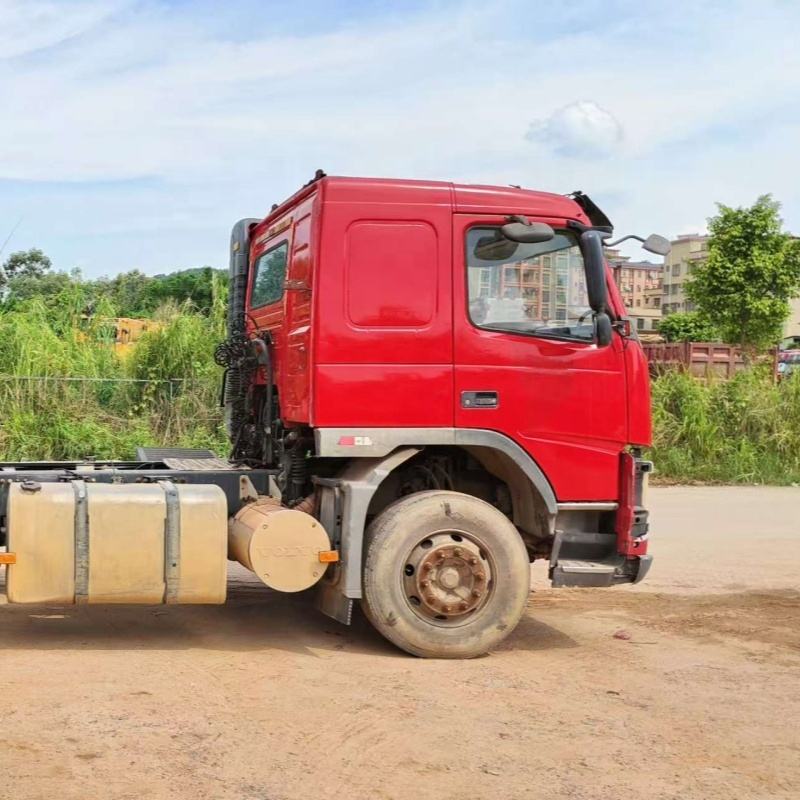 Lowest price used tractor truck for VOLVO FM440 6x2 2012 red manual transmission, 440HP heavy duty red tractor, full left side view outdoor dirt road