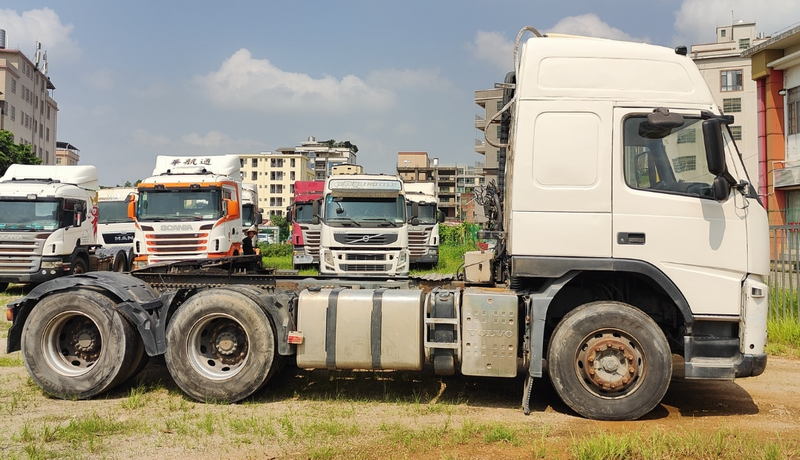 Second hand tractor truck for VOLVO FM480 6x2 high performance tractor trailer for sale, 480HP heavy duty white tractor, full right side view outdoor field scene