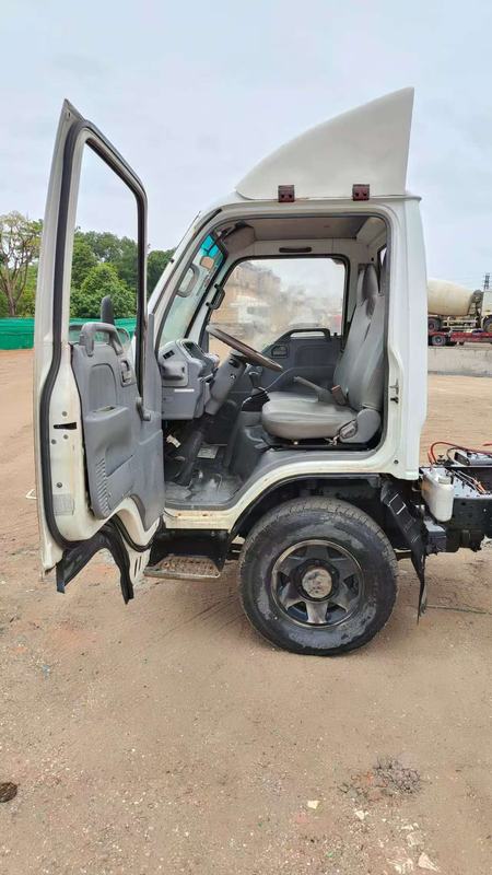 Right side view of used Isuzu 100p mini light truck with cab door open, showing cabin access