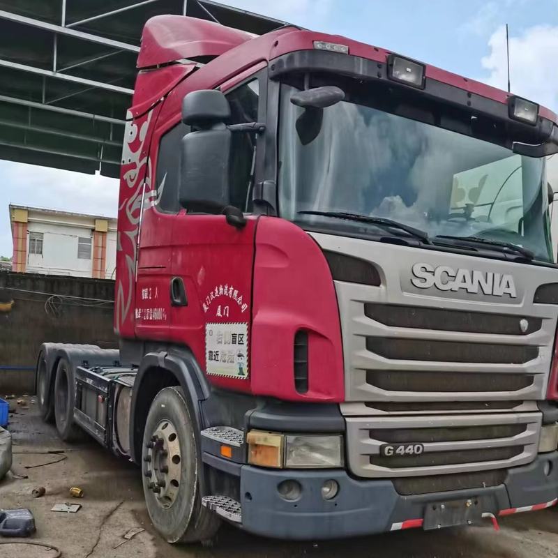 Used SCANIA G440 6x2 diesel tractor truck second hand trailer head for road transport, 440HP heavy duty red diesel tractor, right front 45 degree view outdoor yard scene