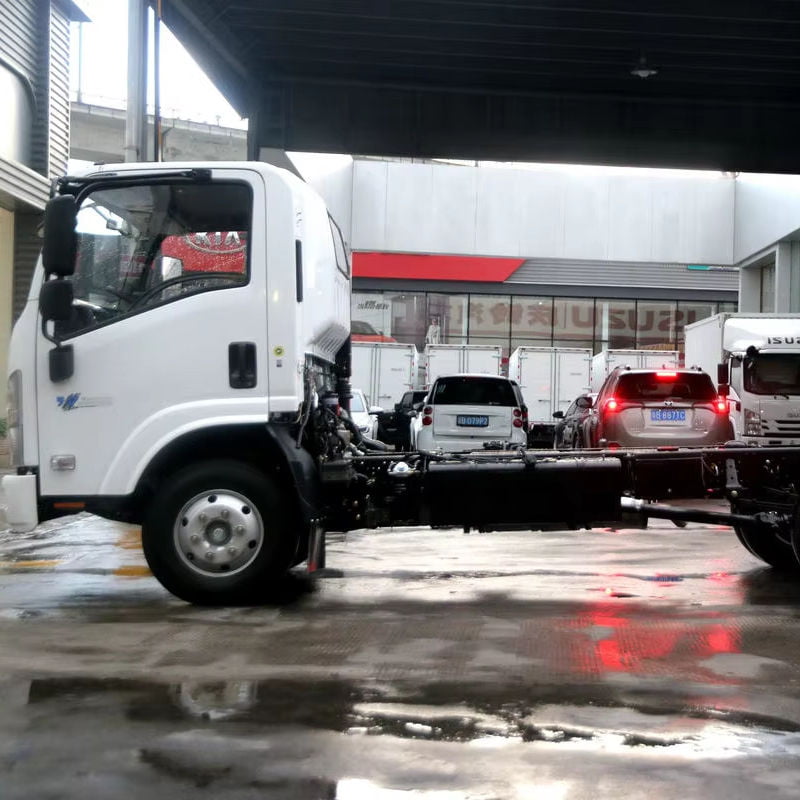 Left side view of used Isuzu M600 diesel truck cab, showing side door in indoor workshop scene